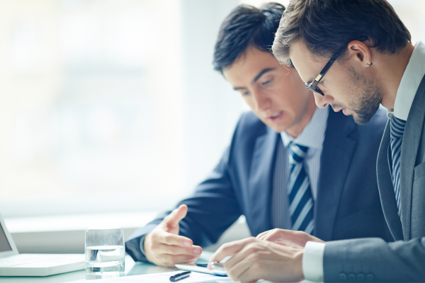 Two business men reviewing their finances from a sheet of paper